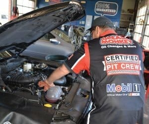 Grease Monkey pit crew working on an engine