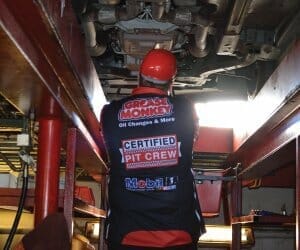 Grease Monkey pit crew working under a car