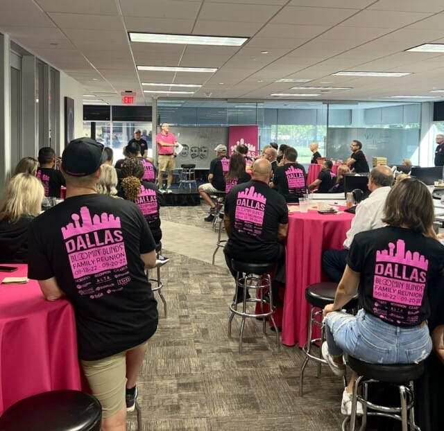 Group of franchisees wearing matching pink t-shirts at a Bloomin' Blinds community meeting or event.