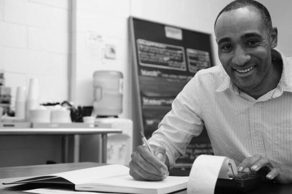 Smiling Man at desk discovering the best franchise resale to buy
