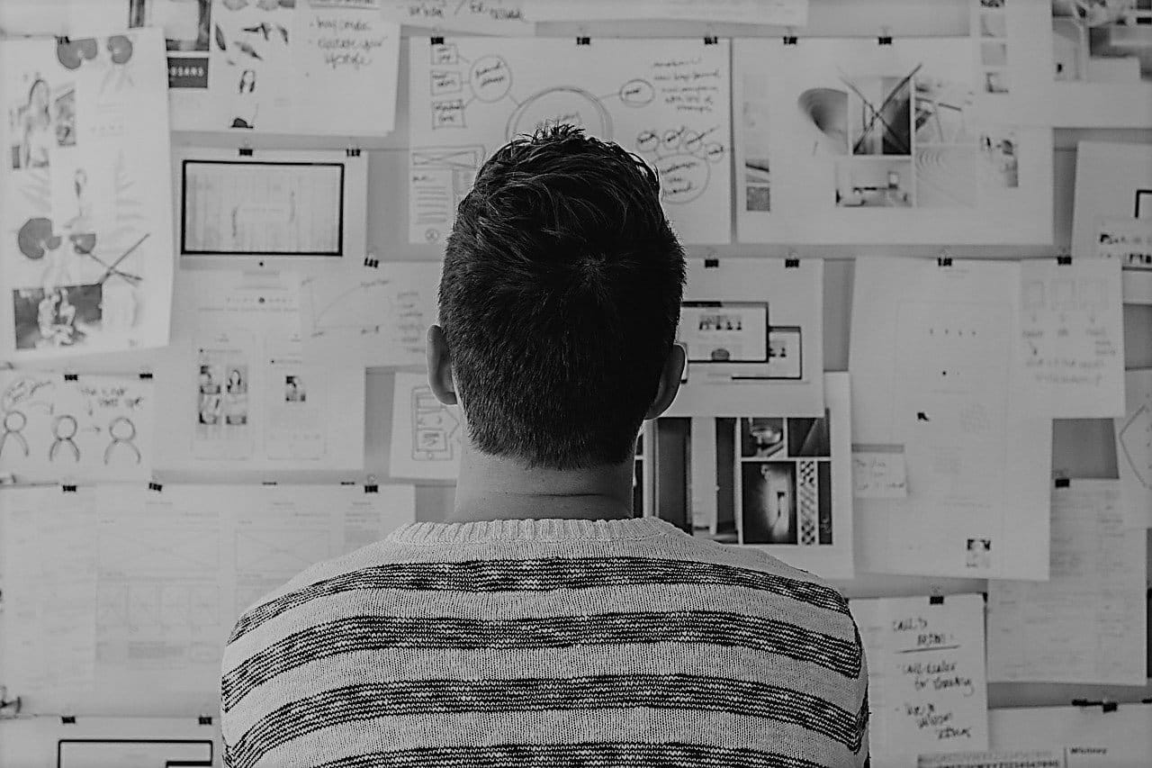 Man Searching bulletin board for cheap franchises for sale